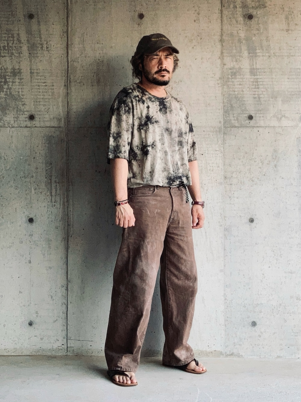 ブラウン系のTシャツ/カットソー、ブラウン系のデニムパンツ、ブラウン系のサンダルを着用したメンズの夏コーディネートの3枚目の写真