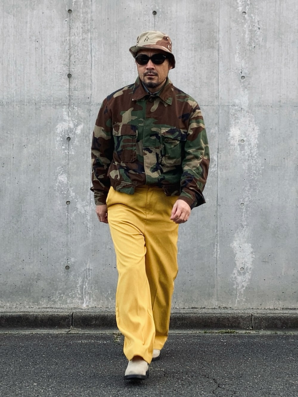 イエロー系のスラックス、その他のミリタリージャケット、ベージュ系のブーツを着用したメンズの冬コーディネートの3枚目の写真