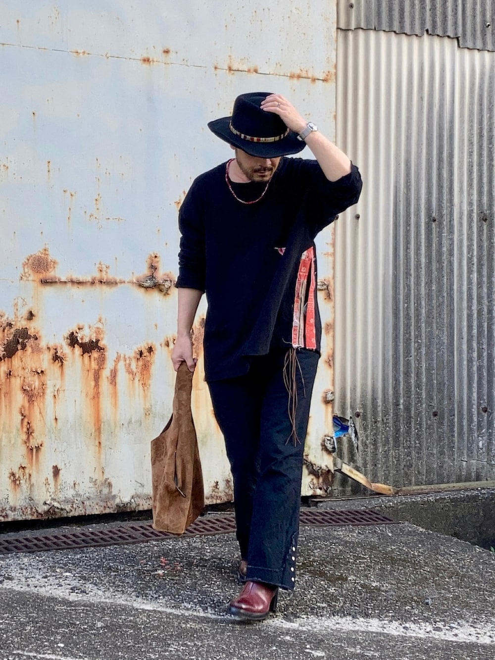 ブラック系のTシャツ/カットソー、ブラック系のその他パンツ、レッド系のブーツを着用したメンズの春コーディネートの3枚目の写真