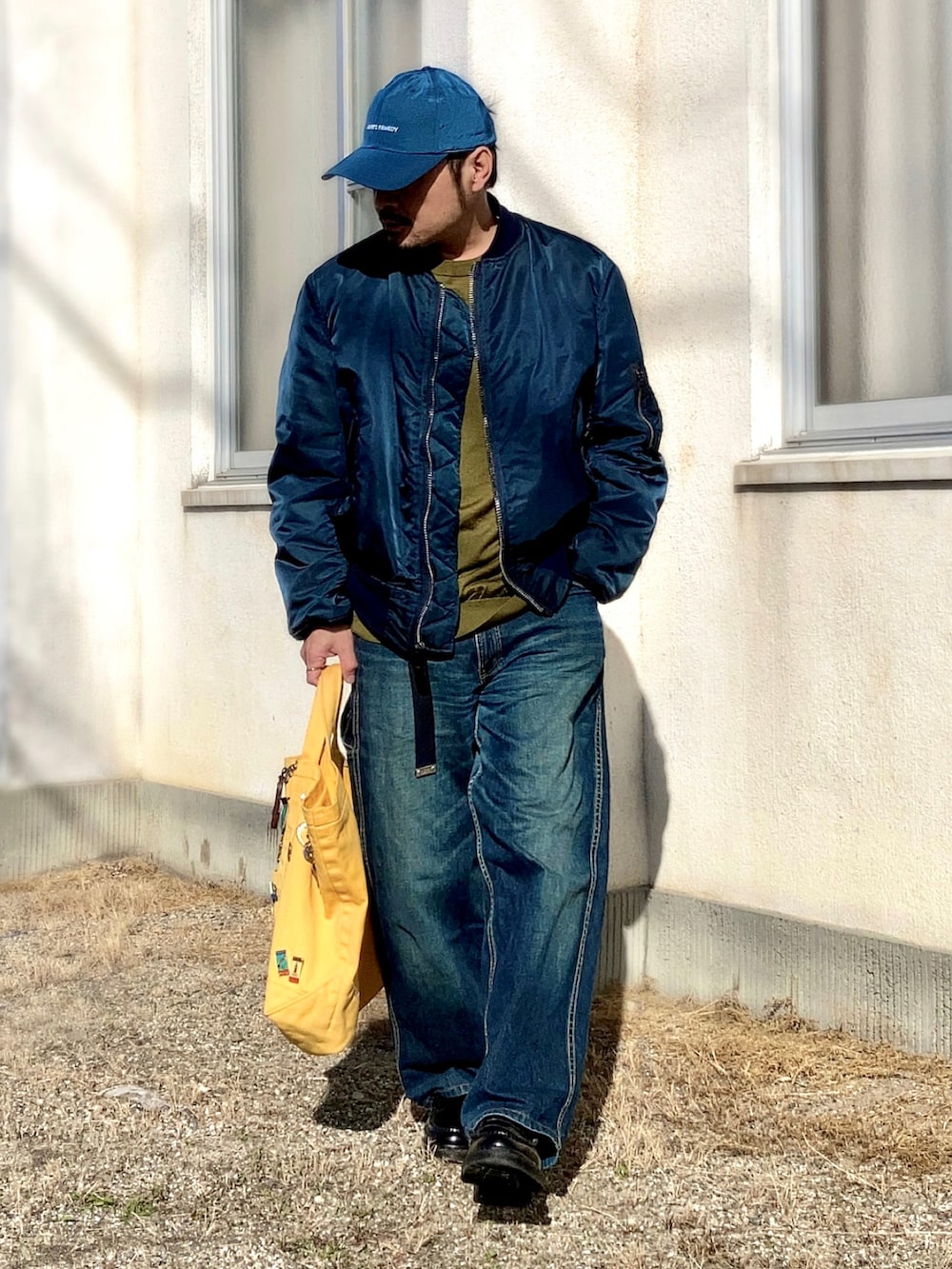 ブルー系のMA-1、ブルー系のデニムパンツ、ブラック系のローファーを着用したメンズの秋コーディネートの3枚目の写真