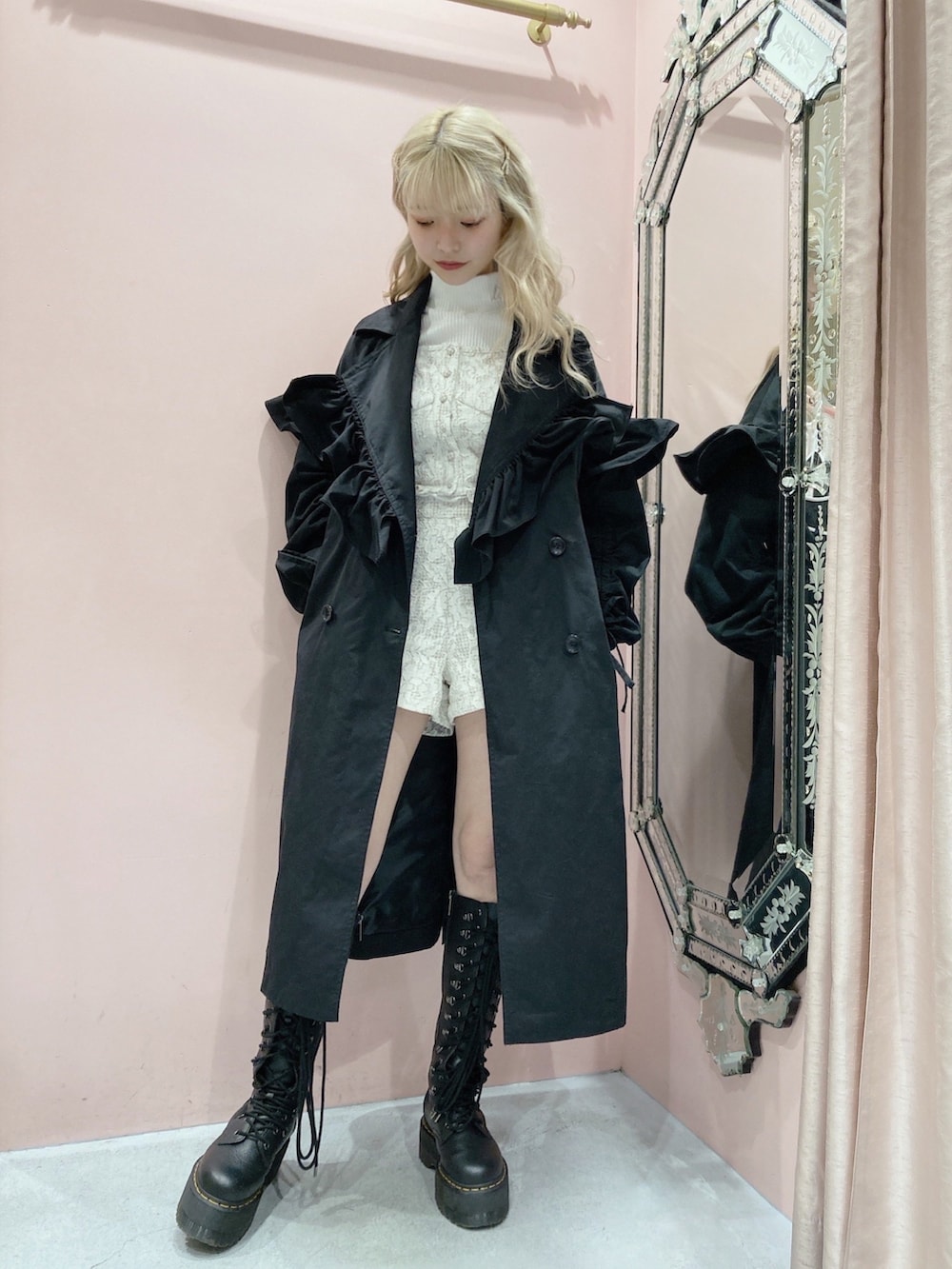 ブラック系のトレンチコート、ホワイト系のニット/セーター、ベージュ系のシャツ/ブラウスを着用したレディースの春コーディネートの2枚目の写真