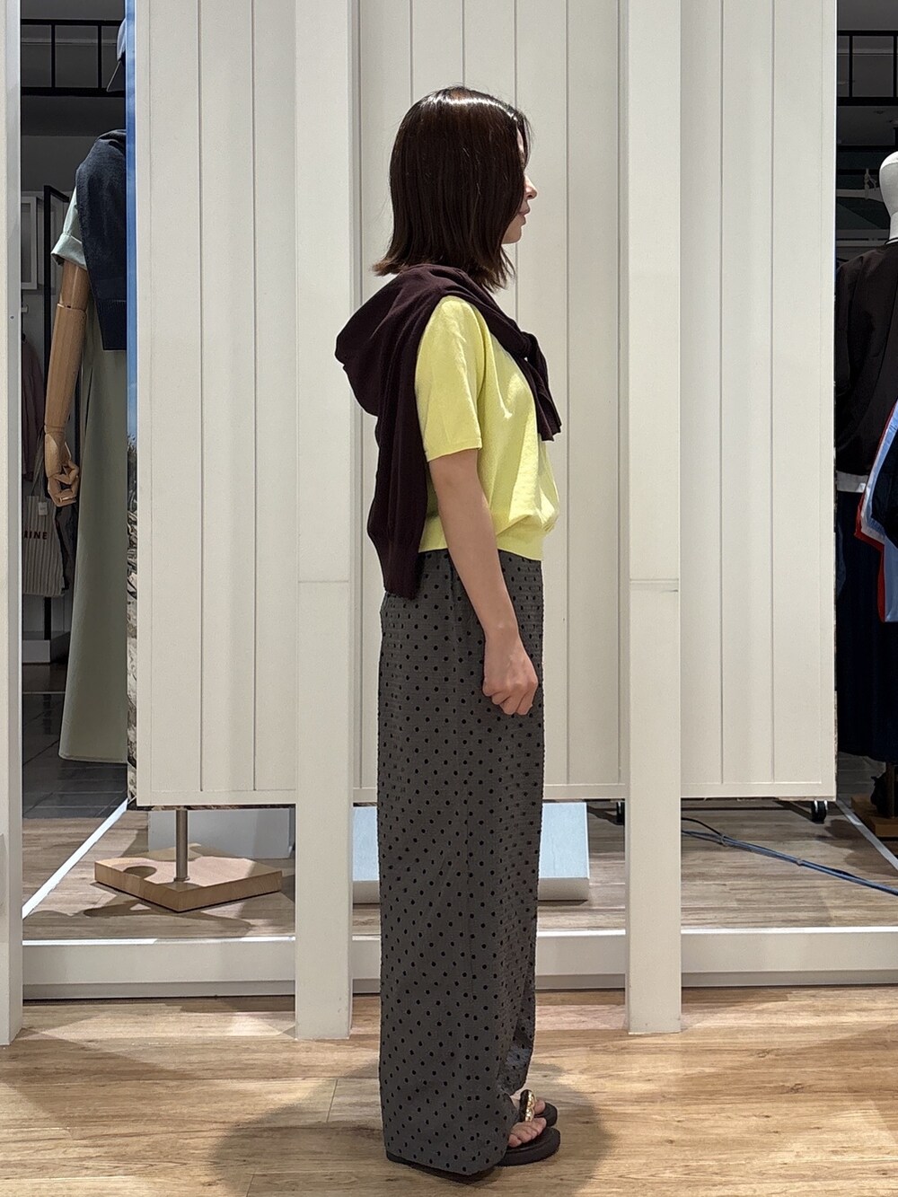 イエロー系のニット/セーター、グレー系のその他パンツ、ブラウン系のサンダルを着用したレディースの夏コーディネートの4枚目の写真