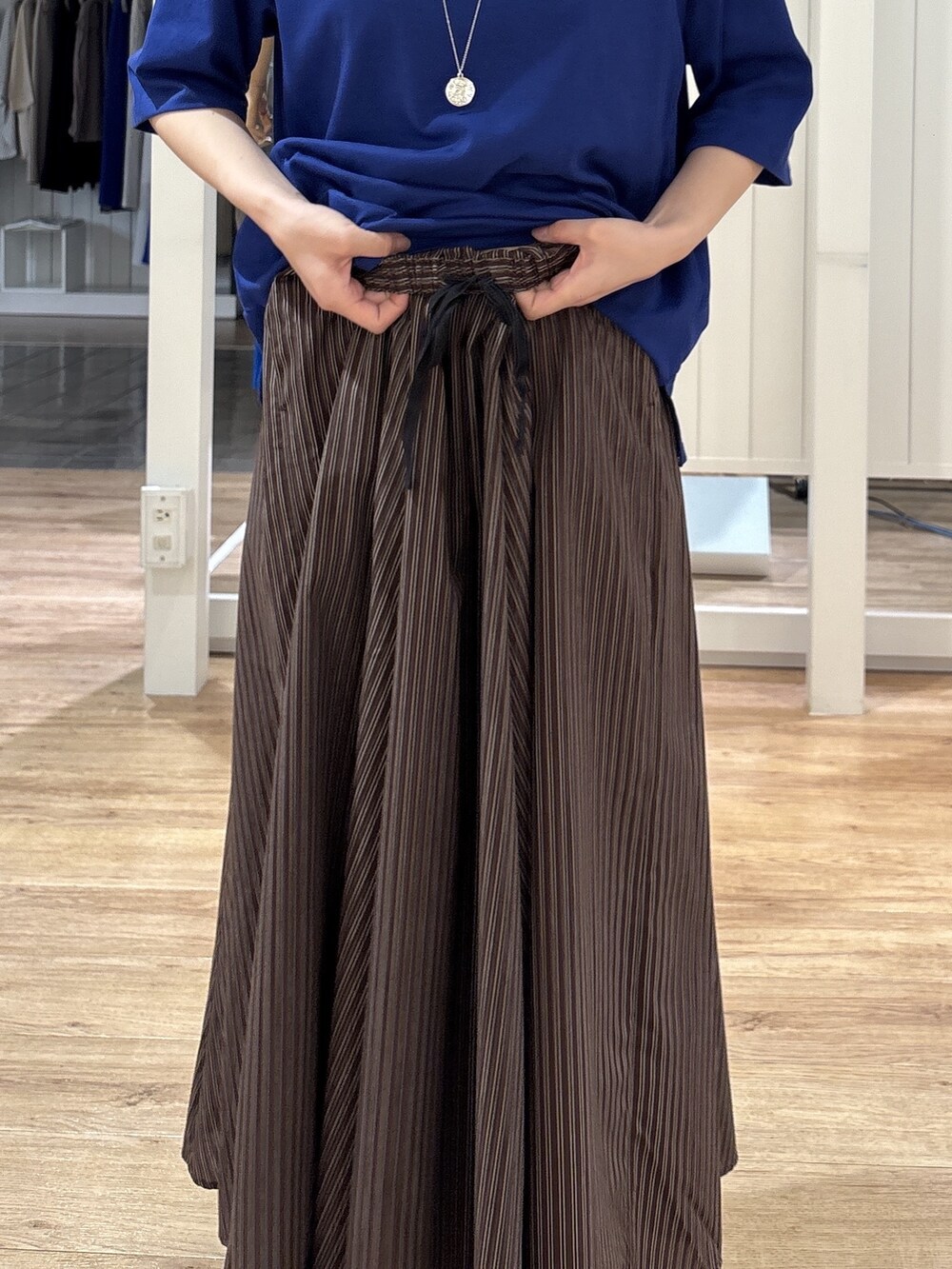 ブルー系のTシャツ/カットソー、ブラウン系のスカート、ブラック系のパンプスを着用したレディースの夏コーディネートの9枚目の写真