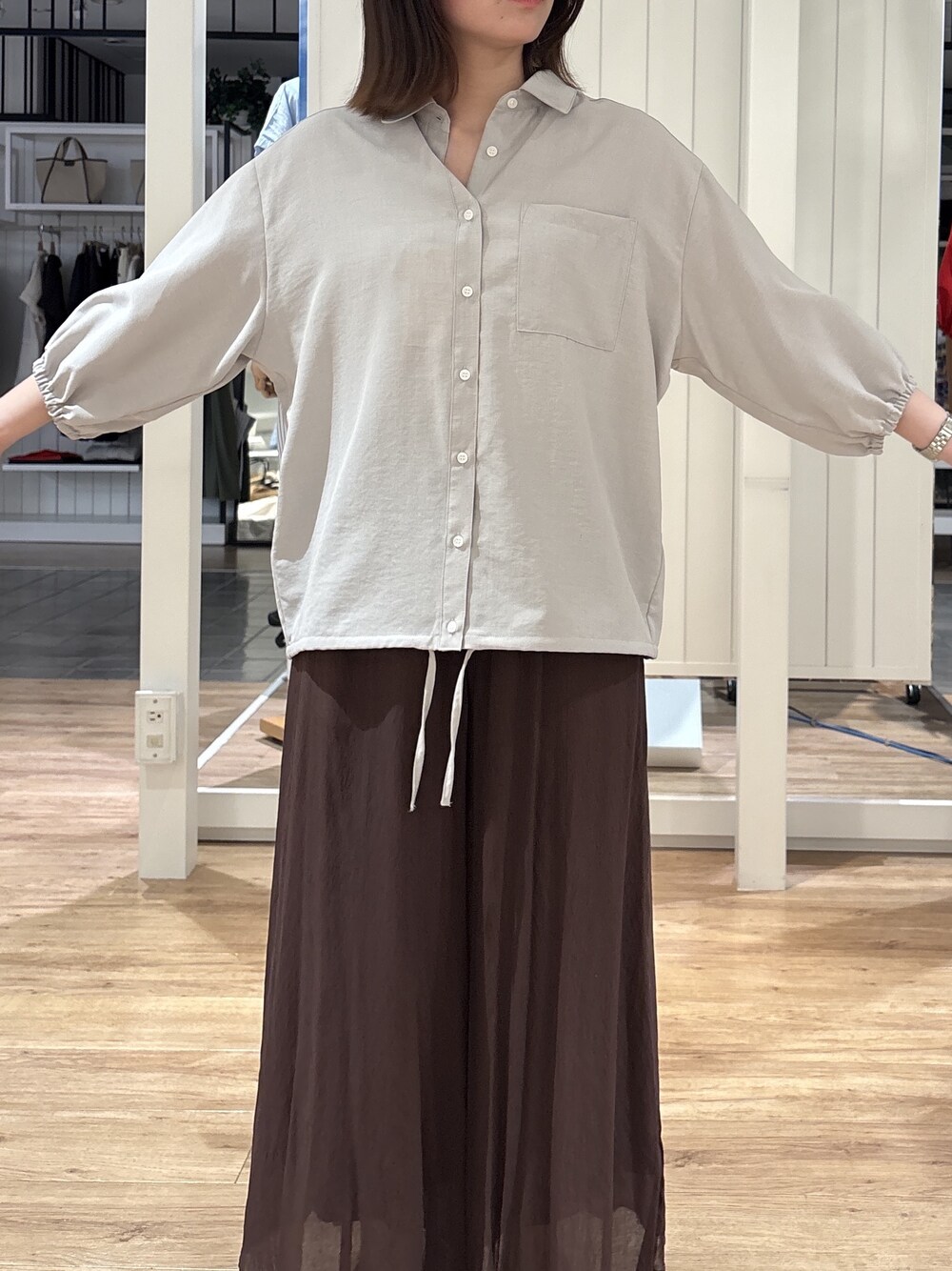 グレー系のシャツ/ブラウス、ブラウン系のその他パンツ、ブルー系のショルダーバッグを着用したレディースの春コーディネートの5枚目の写真