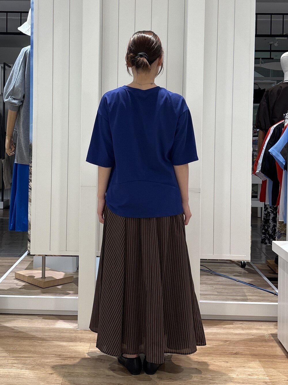 ブルー系のTシャツ/カットソー、ブラウン系のスカート、ブラック系のパンプスを着用したレディースの夏コーディネートの3枚目の写真
