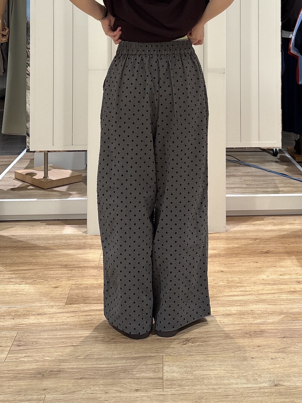 イエロー系のニット/セーター、グレー系のその他パンツ、ブラウン系のサンダルを着用したレディースの夏コーディネートの9枚目の写真