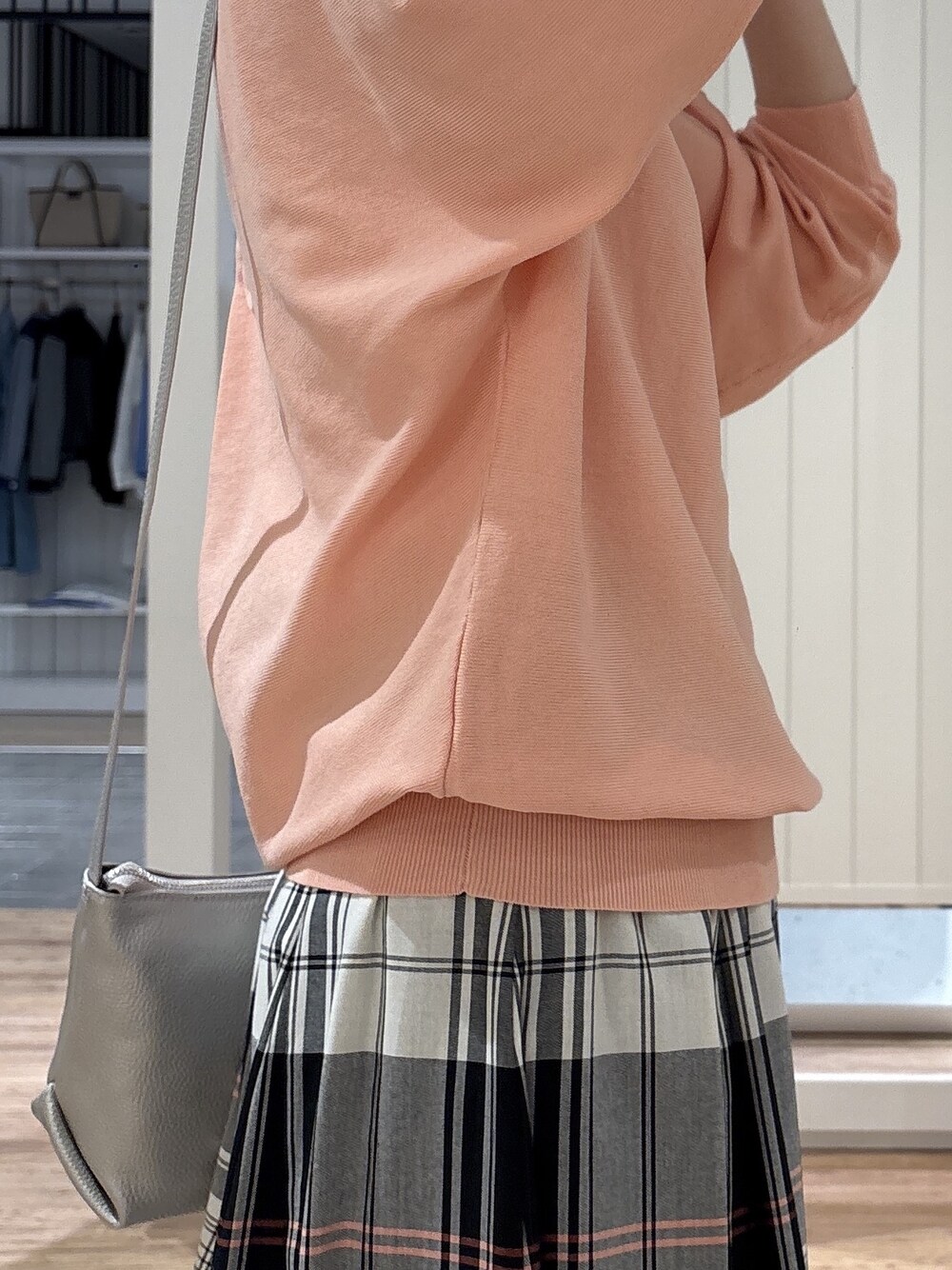 レッド系のスカート、オレンジ系のニット/セーター、シルバー系のショルダーバッグを着用したレディースの春コーディネートの4枚目の写真