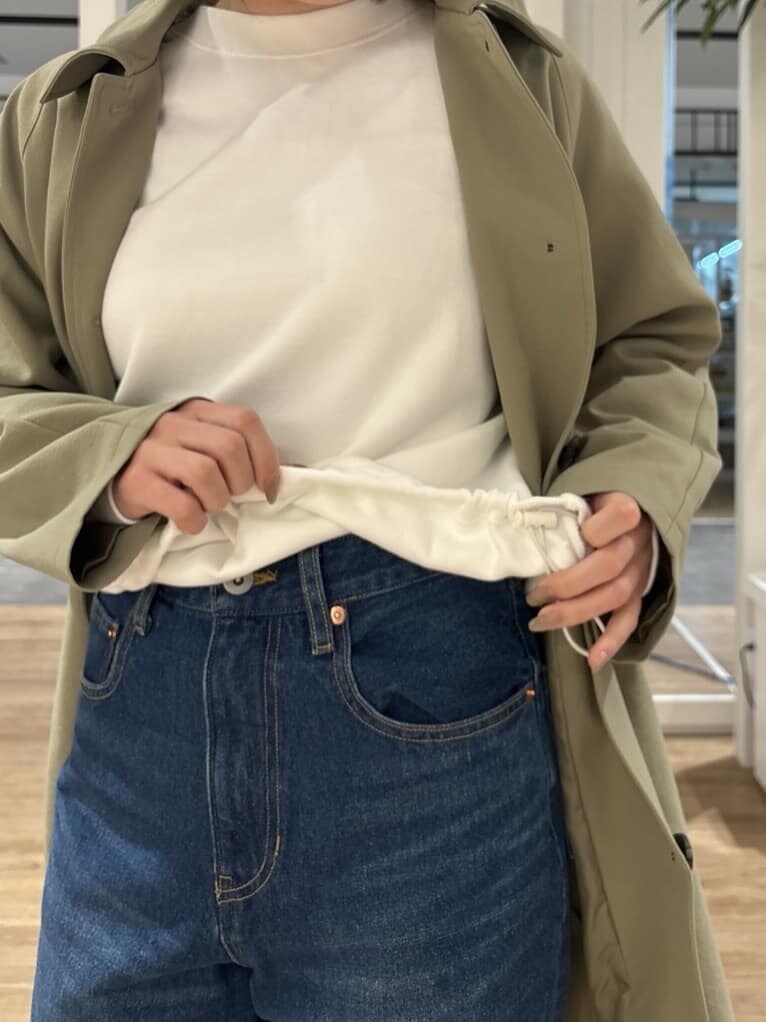 ホワイト系のTシャツ/カットソー、グリーン系のステンカラーコート、ベージュ系のショルダーバッグを着用したレディースの冬コーディネートの6枚目の写真