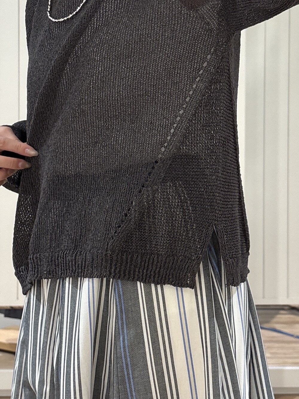 ホワイト系のスカート、ベージュ系のトートバッグ、ブラック系のサンダルを着用したレディースの春コーディネートの6枚目の写真