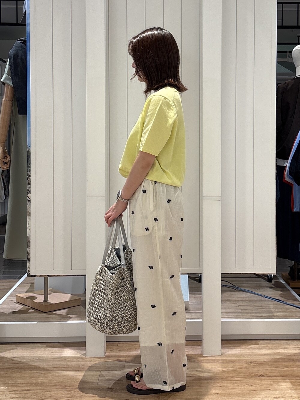 イエロー系のニット/セーター、ホワイト系のその他パンツ、ブラウン系のサンダルを着用したレディースの夏コーディネートの3枚目の写真