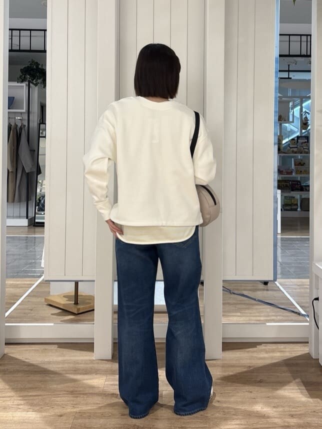 ブルー系のその他パンツ、ベージュ系のショルダーバッグ、イエロー系のTシャツ/カットソーを着用したレディースの冬コーディネートの3枚目の写真