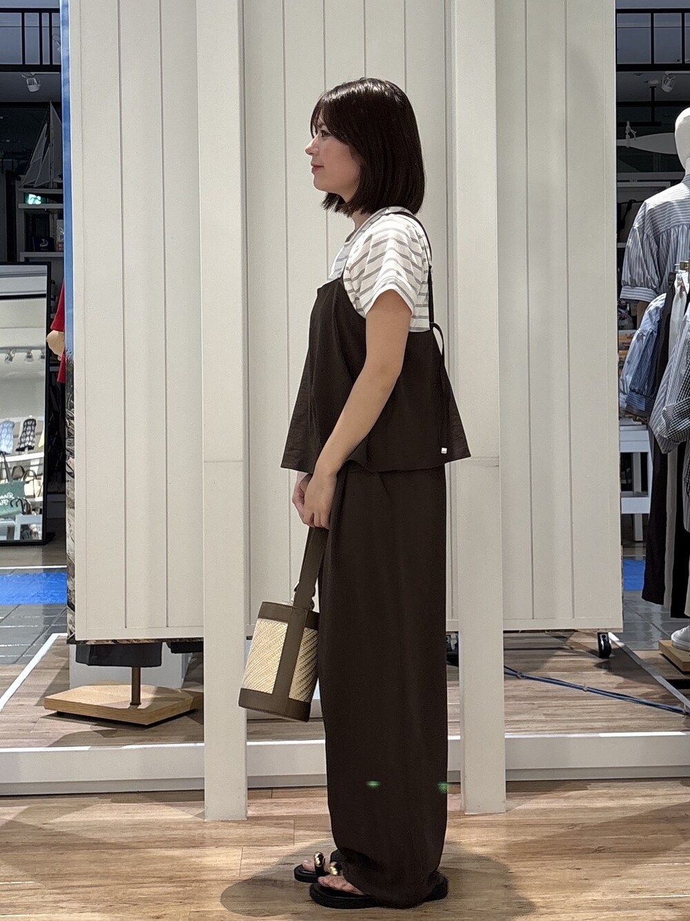 ブラウン系のサロペット/オーバーオール、グレー系のTシャツ/カットソー、ベージュ系のショルダーバッグを着用したレディースの春コーディネートの2枚目の写真