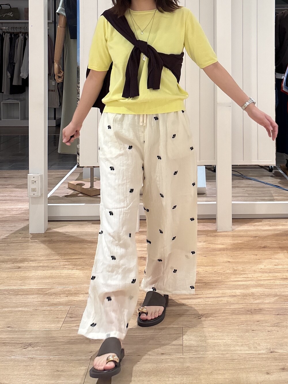 イエロー系のニット/セーター、ホワイト系のその他パンツ、ブラウン系のサンダルを着用したレディースの夏コーディネートの8枚目の写真
