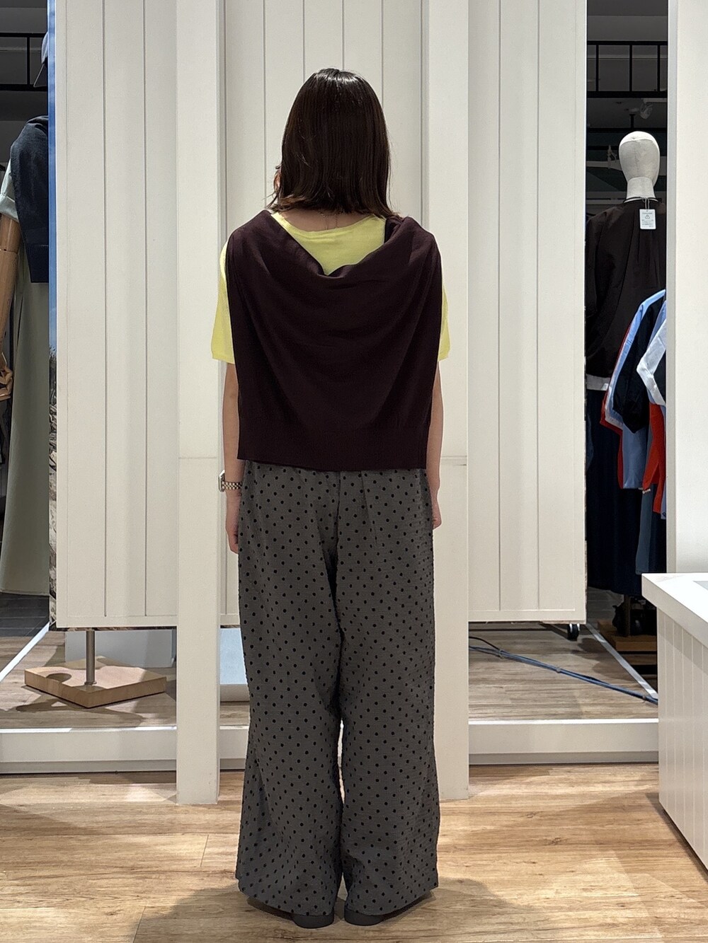 イエロー系のニット/セーター、グレー系のその他パンツ、ブラウン系のサンダルを着用したレディースの夏コーディネートの5枚目の写真