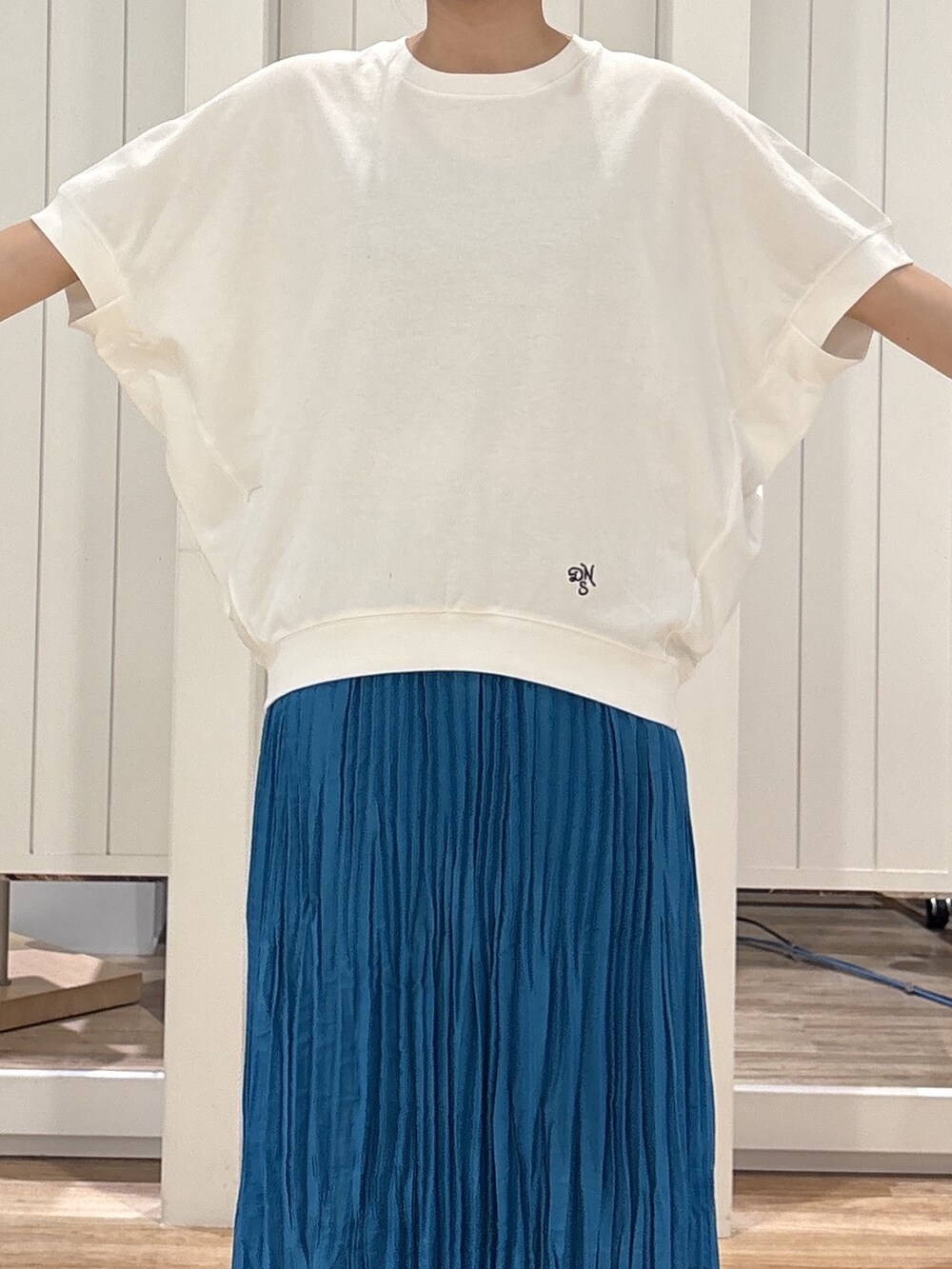 ホワイト系のTシャツ/カットソー、ブルー系のスカート、ブラック系のパンプスを着用したレディースの夏コーディネートの4枚目の写真