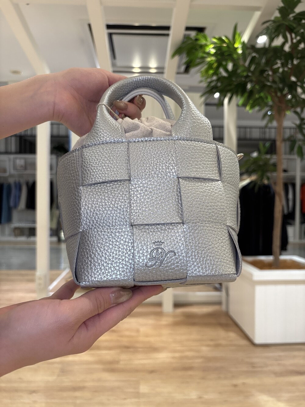 ブルー系のスカート、ブラック系のパンプス、シルバー系のトートバッグを着用したレディースの春コーディネートの7枚目の写真
