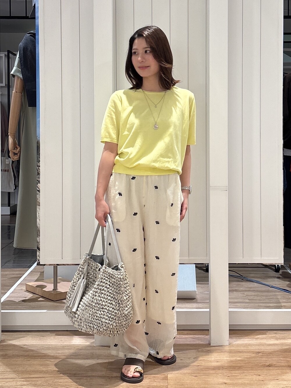 イエロー系のニット/セーター、ホワイト系のその他パンツ、ブラウン系のサンダルを着用したレディースの夏コーディネートの2枚目の写真