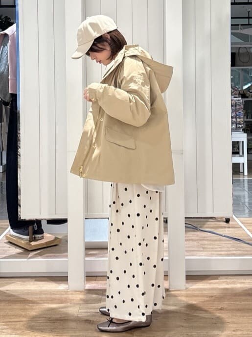ベージュ系のブルゾン、グリーン系のニット/セーター、ホワイト系のシャツ/ブラウスを着用したレディースの春コーディネートの2枚目の写真