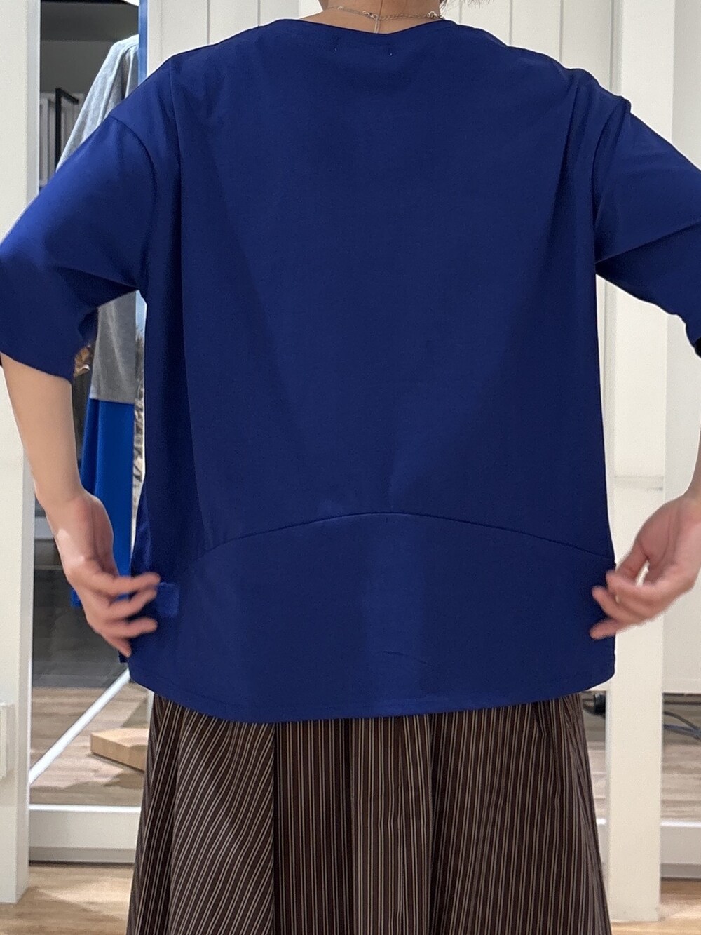 ブルー系のTシャツ/カットソー、ブラウン系のスカート、ブラック系のパンプスを着用したレディースの夏コーディネートの5枚目の写真