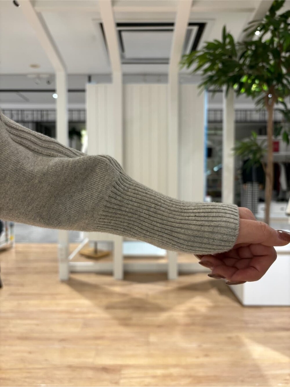 グレー系のニット/セーター、ブラウン系のスカート、ブラック系のブーツを着用したレディースの冬コーディネートの5枚目の写真