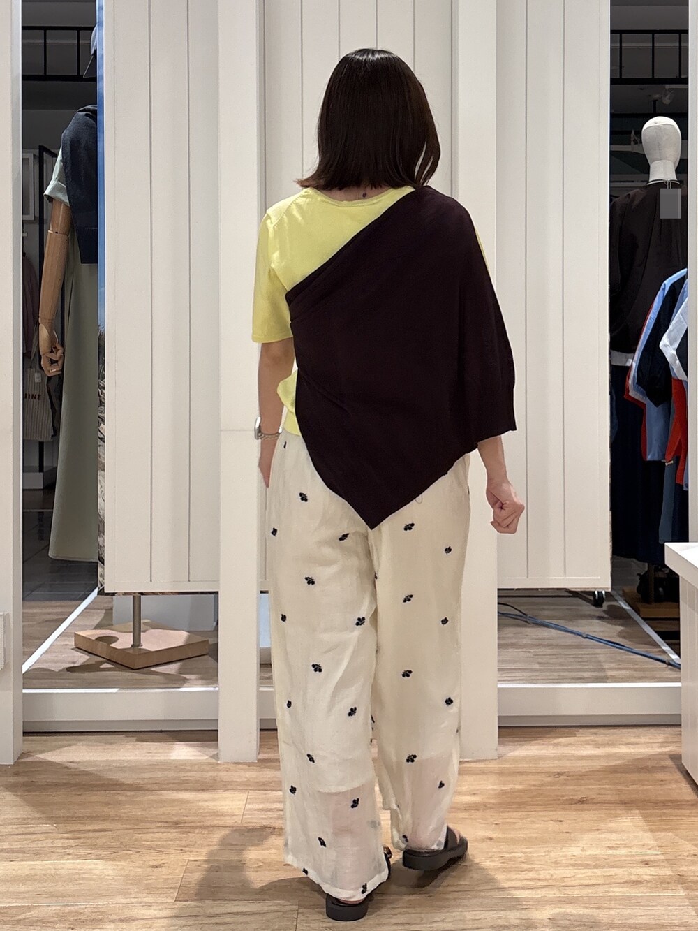 イエロー系のニット/セーター、ホワイト系のその他パンツ、ブラウン系のサンダルを着用したレディースの夏コーディネートの5枚目の写真