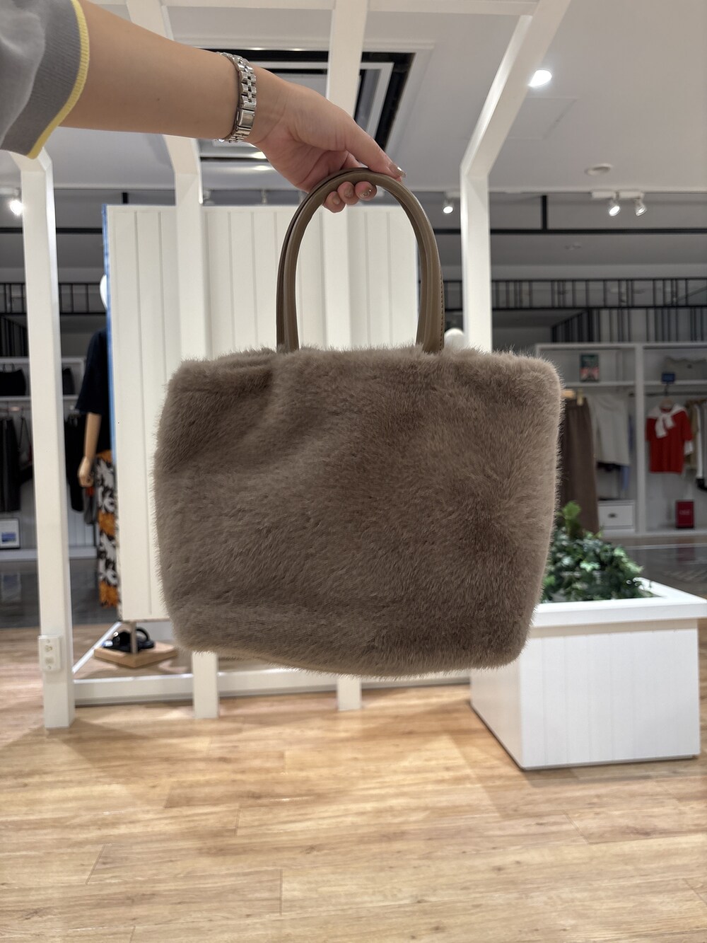 グレー系のニット/セーター、ブルー系のスカート、ブラック系のパンプスを着用したレディースの秋コーディネートの8枚目の写真