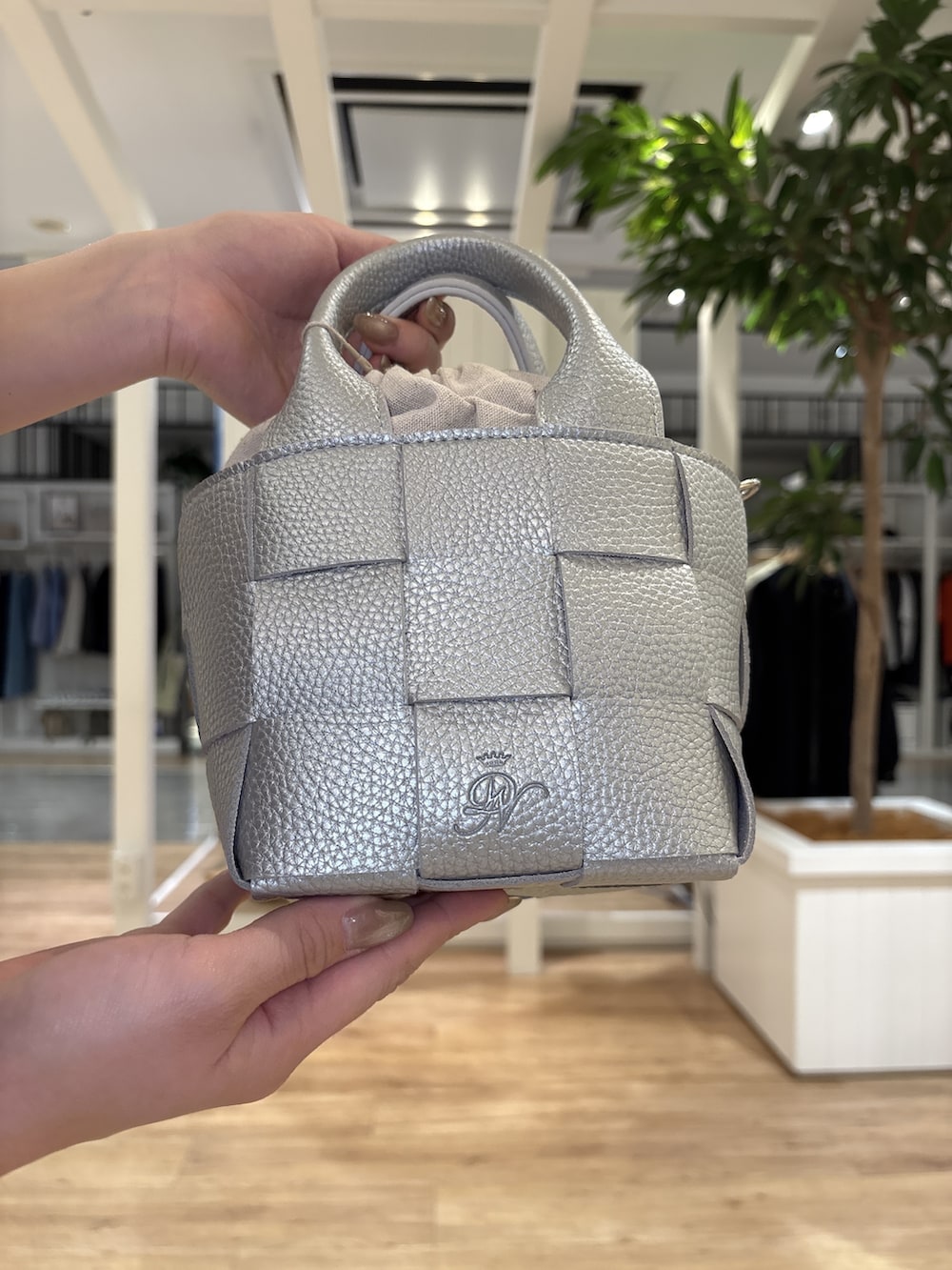 ブルー系のスカート、ブラック系のパンプス、グレー系のポロシャツを着用したレディースの春コーディネートの7枚目の写真