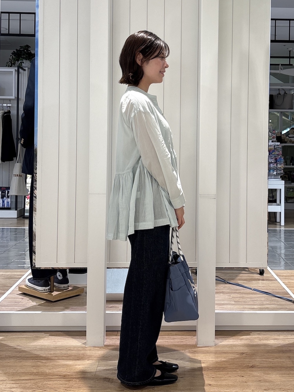 グリーン系のシャツ/ブラウス、ブルー系のデニムパンツ、ブラック系のパンプスを着用したレディースの春コーディネートの2枚目の写真