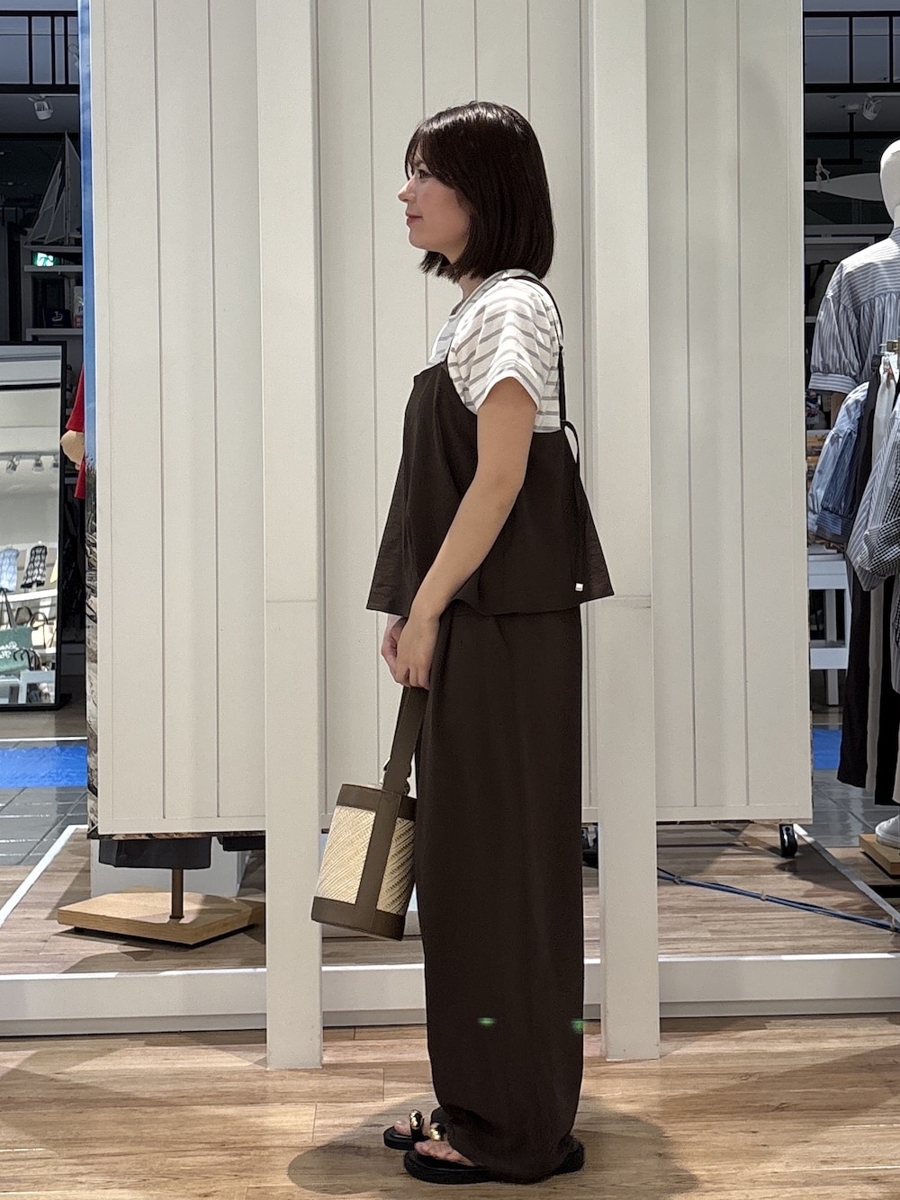 グレー系のTシャツ/カットソー、ブラウン系のサロペット/オーバーオール、ベージュ系のショルダーバッグを着用したレディースの春コーディネートの2枚目の写真