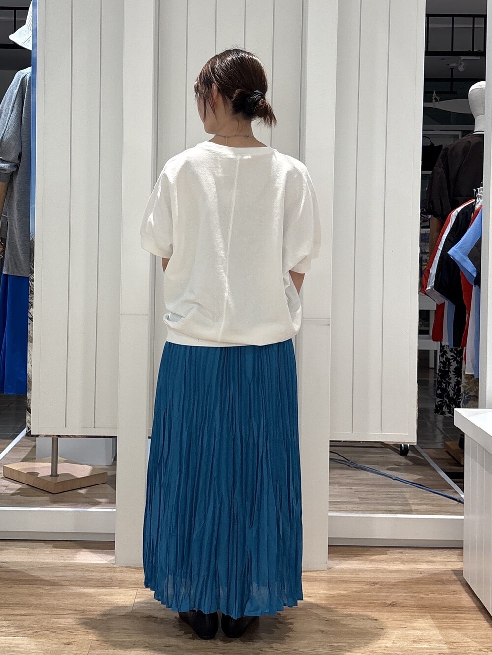 ホワイト系のTシャツ/カットソー、ブルー系のスカート、ブラック系のパンプスを着用したレディースの夏コーディネートの3枚目の写真