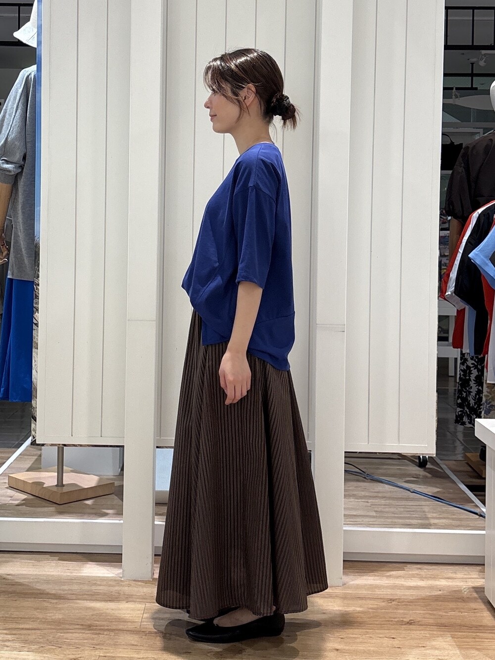 ブルー系のTシャツ/カットソー、ブラウン系のスカート、ブラック系のパンプスを着用したレディースの夏コーディネートの2枚目の写真