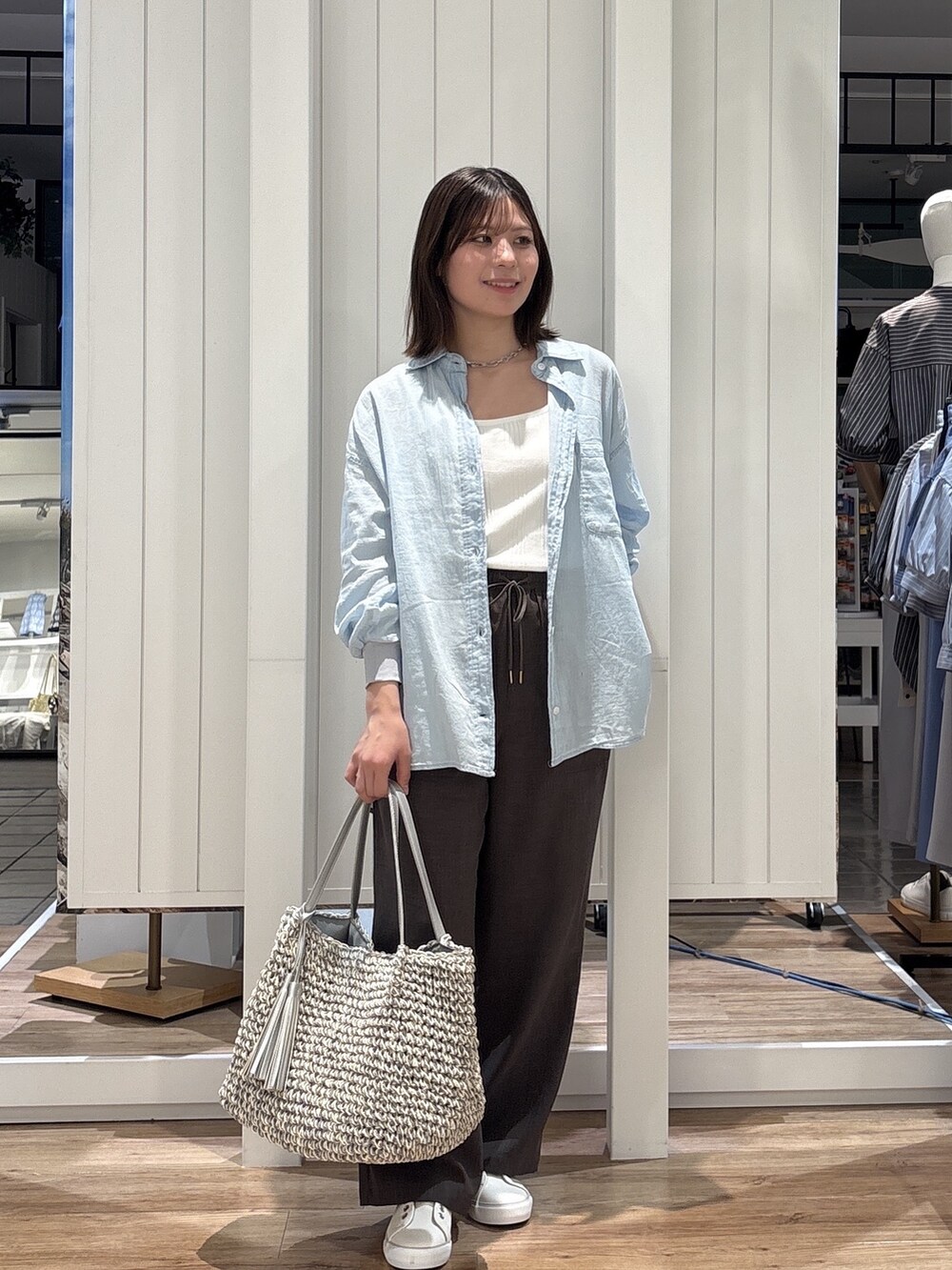ブルー系のシャツ/ブラウス、ブラウン系のその他パンツ、ホワイト系のスニーカーを着用したレディースの春コーディネートの2枚目の写真