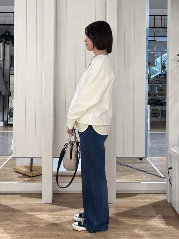 ブルー系のその他パンツ、ベージュ系のショルダーバッグ、イエロー系のTシャツ/カットソーを着用したレディースの冬コーディネートの2枚目の写真