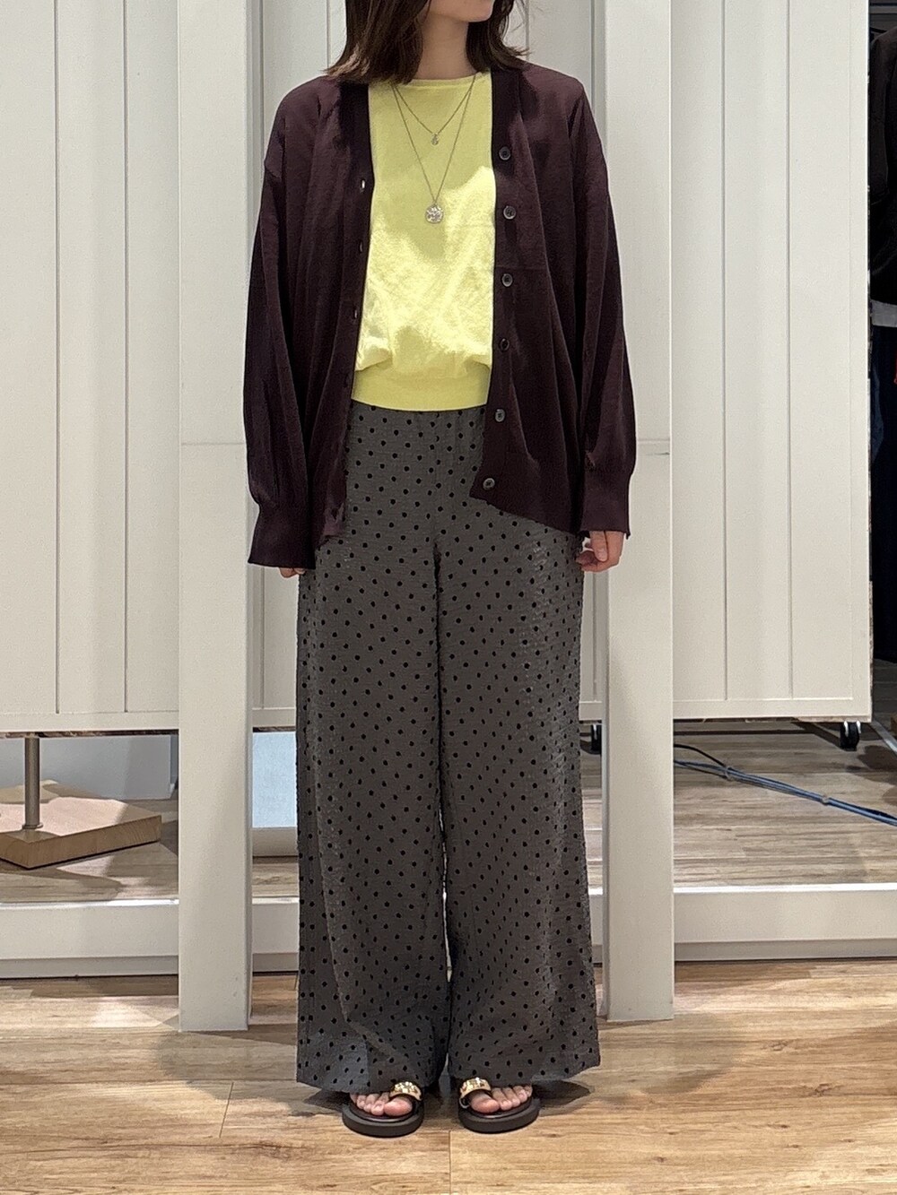イエロー系のニット/セーター、グレー系のその他パンツ、ブラウン系のサンダルを着用したレディースの夏コーディネートの3枚目の写真