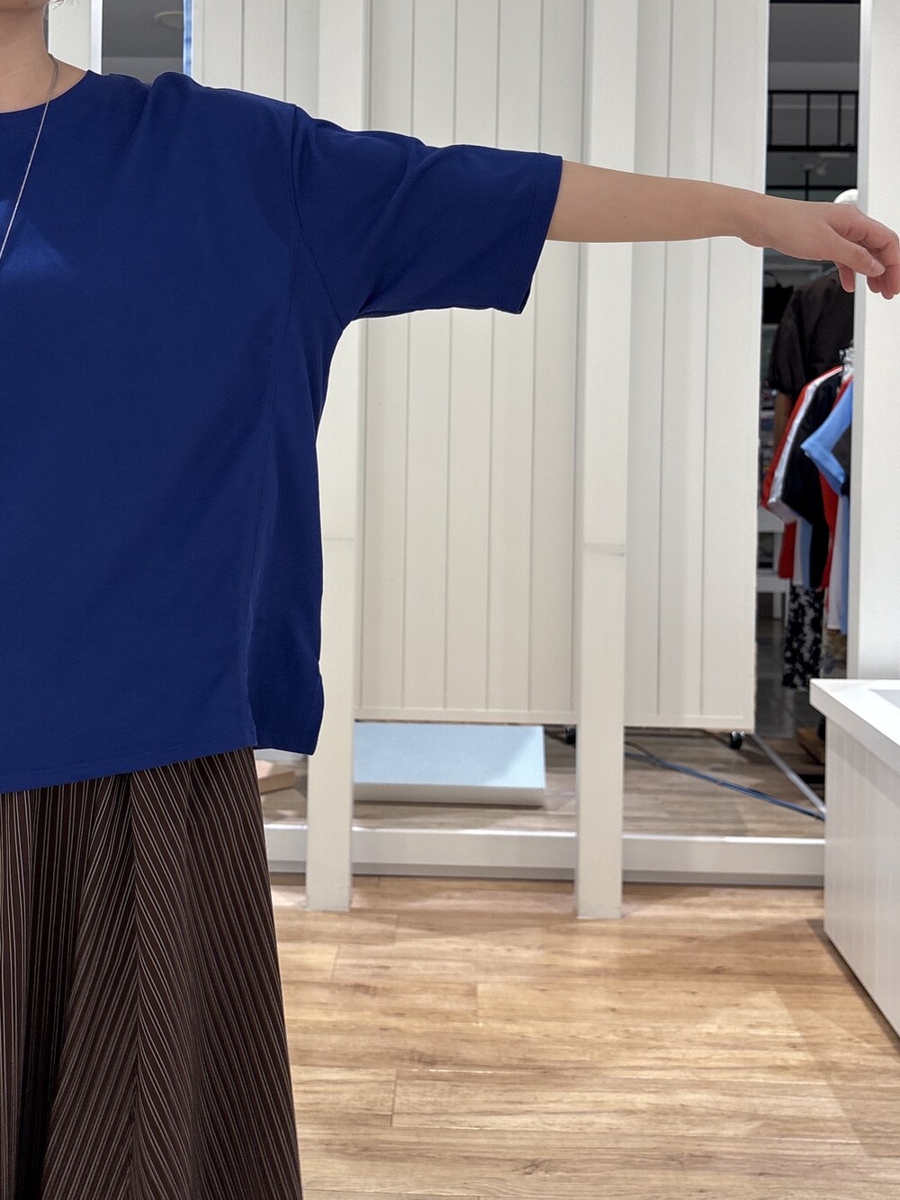 ブルー系のTシャツ/カットソー、ブラウン系のスカート、ブラック系のパンプスを着用したレディースの夏コーディネートの6枚目の写真