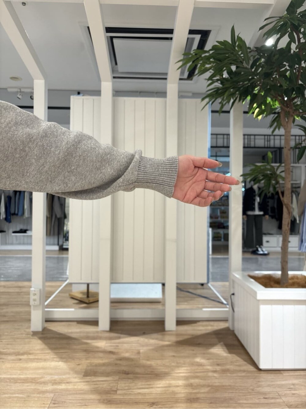 グレー系のニット/セーター、ブラック系のスカート、ブルー系のトートバッグを着用したレディースの冬コーディネートの6枚目の写真