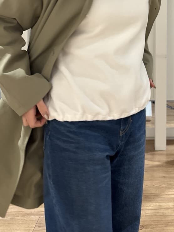 ホワイト系のTシャツ/カットソー、グリーン系のステンカラーコート、ベージュ系のショルダーバッグを着用したレディースの冬コーディネートの7枚目の写真