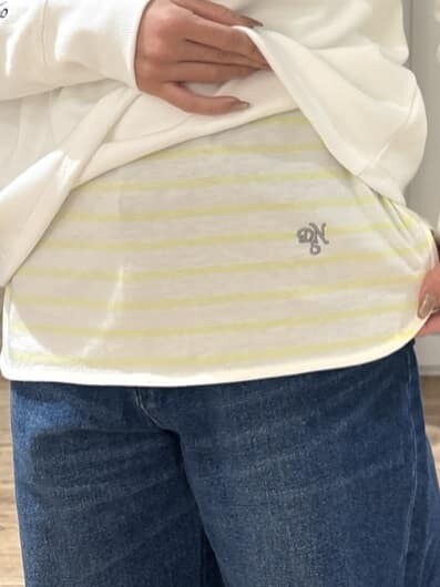ブルー系のその他パンツ、ベージュ系のショルダーバッグ、イエロー系のTシャツ/カットソーを着用したレディースの冬コーディネートの9枚目の写真