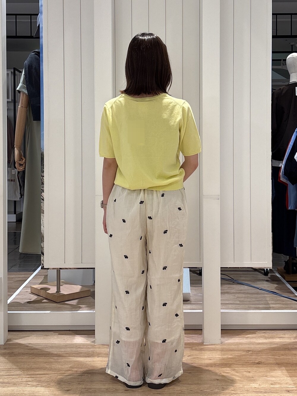 イエロー系のニット/セーター、ホワイト系のその他パンツ、ブラウン系のサンダルを着用したレディースの夏コーディネートの4枚目の写真