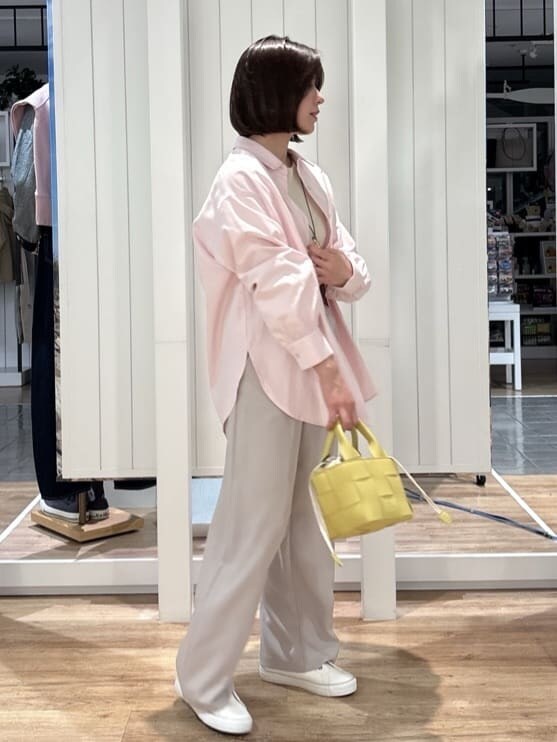 ピンク系のシャツ/ブラウス、ホワイト系のニット/セーター、ベージュ系のその他パンツを着用したレディースの春コーディネートの2枚目の写真