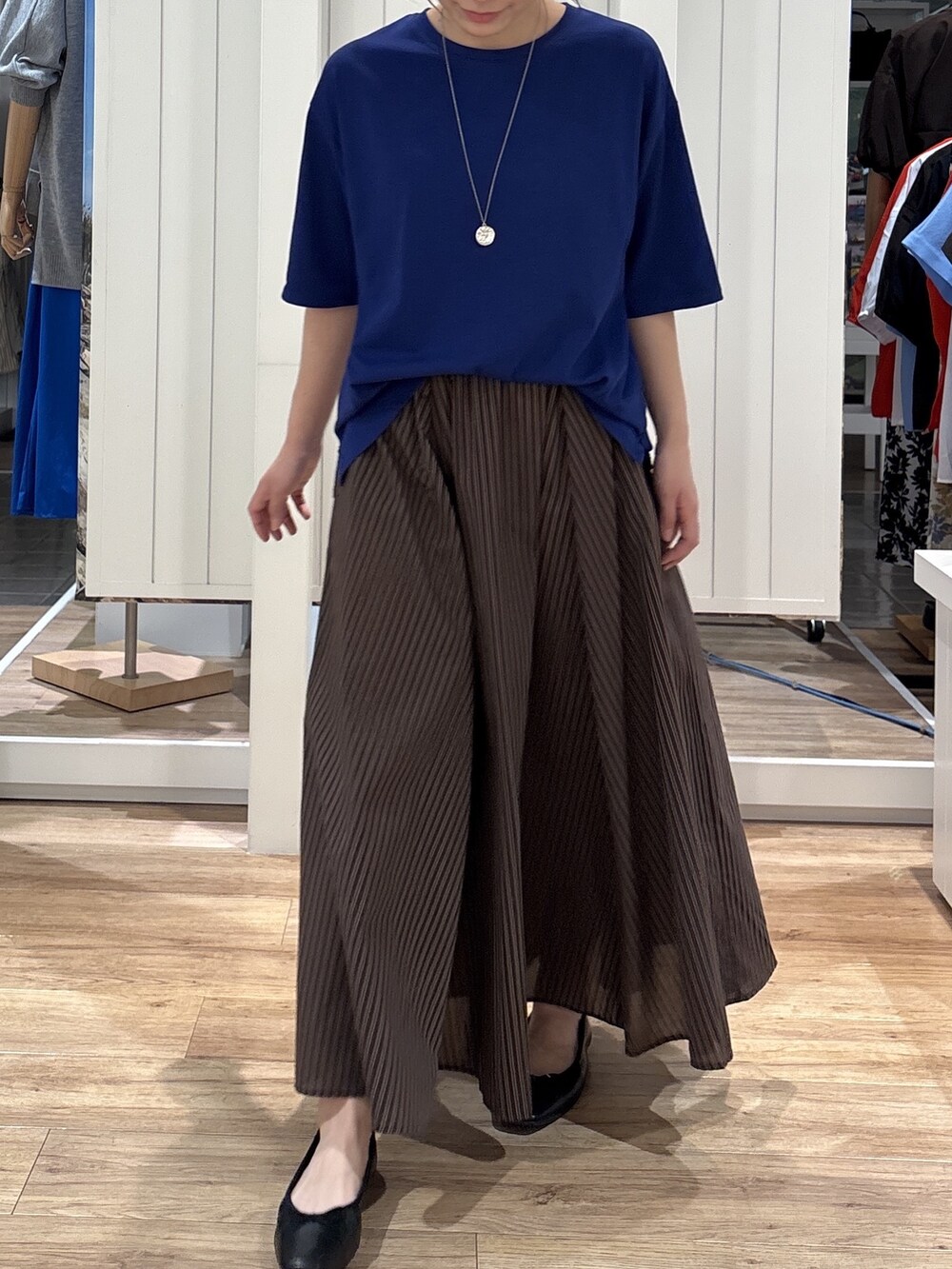 ブルー系のTシャツ/カットソー、ブラウン系のスカート、ブラック系のパンプスを着用したレディースの夏コーディネートの4枚目の写真