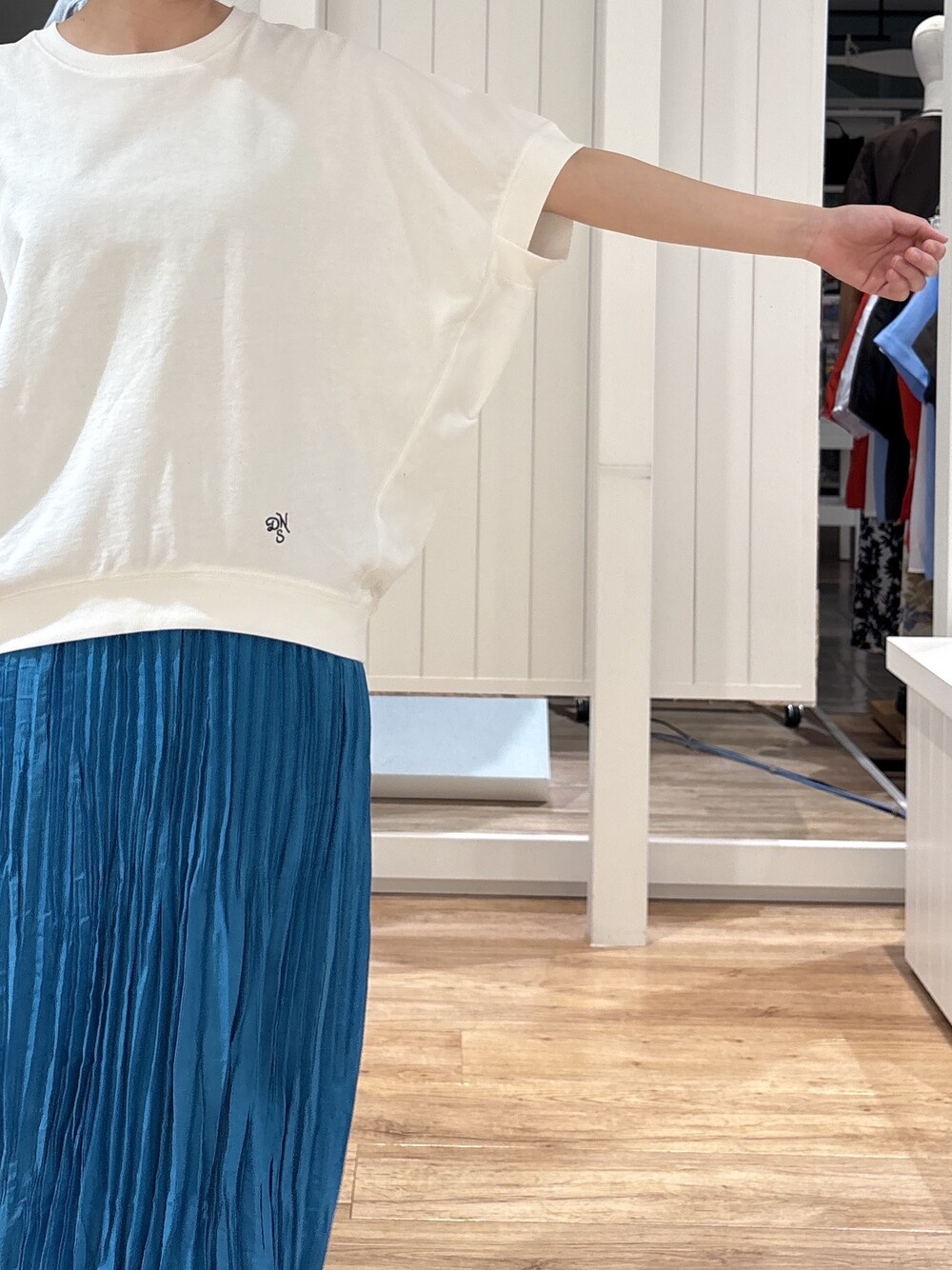 ホワイト系のTシャツ/カットソー、ブルー系のスカート、ブラック系のパンプスを着用したレディースの夏コーディネートの6枚目の写真