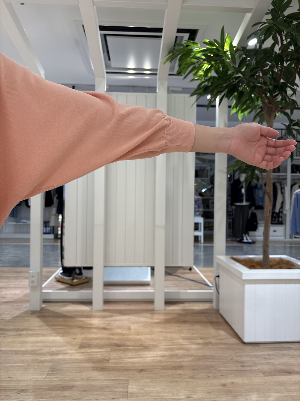 レッド系のスカート、オレンジ系のニット/セーター、シルバー系のショルダーバッグを着用したレディースの春コーディネートの5枚目の写真