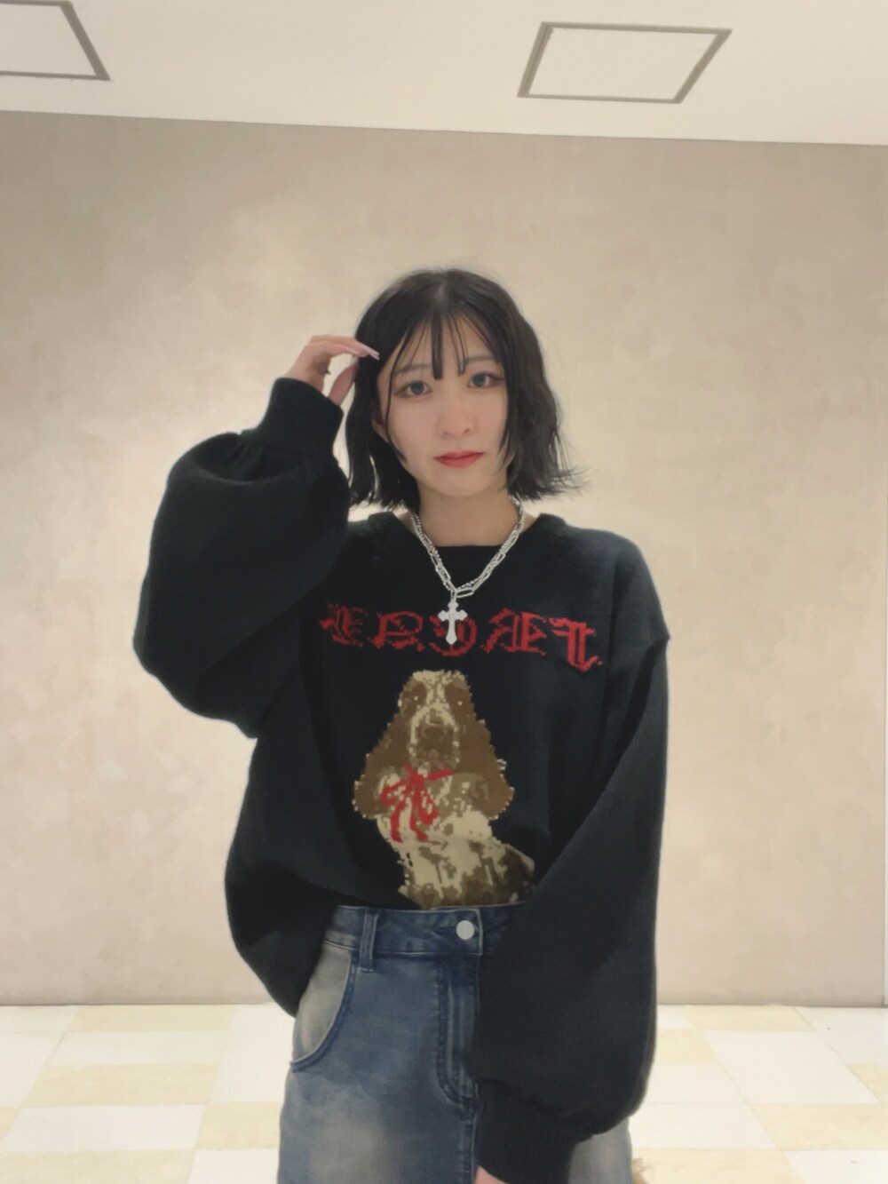 ブラック系のニット/セーター、ブルー系のスカート、ブラック系のブーツを着用したレディースの秋コーディネートの4枚目の写真