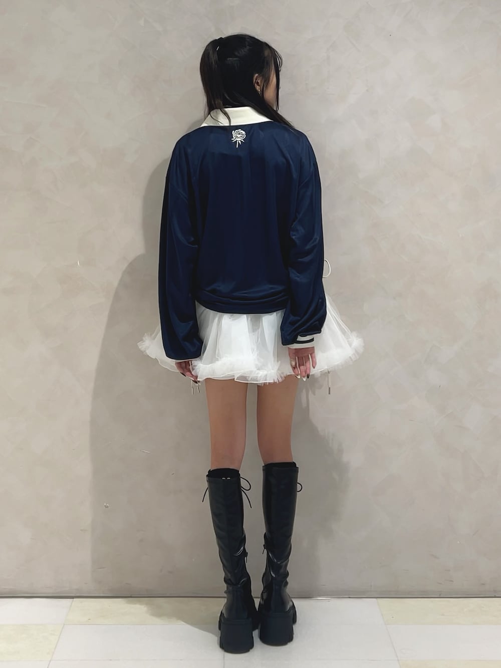 ブルー系のTシャツ/カットソー、ホワイト系のスカート、ブラック系のブーツを着用したレディースの秋コーディネートの3枚目の写真