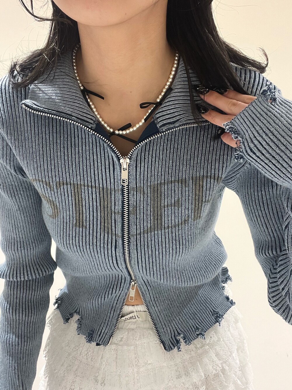 ブルー系のニット/セーター、ホワイト系のその他パンツ、シルバー系のメガネを着用したレディースの春コーディネートの6枚目の写真