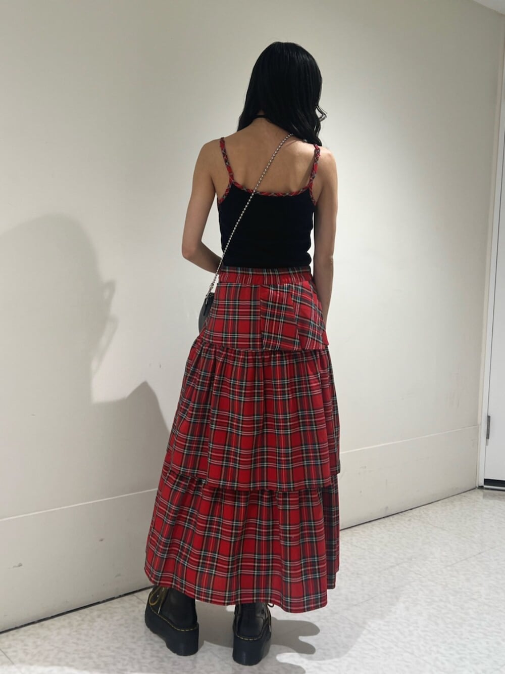 ブラック系のキャミソール、レッド系のスカート、ブラック系のボストンバッグを着用したレディースの春コーディネートの3枚目の写真