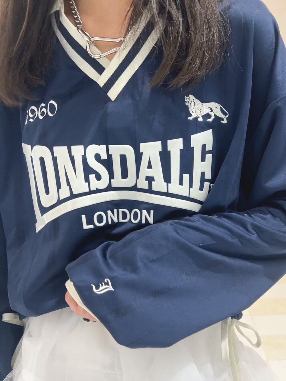 ブルー系のTシャツ/カットソー、ホワイト系のスカート、ブラック系のブーツを着用したレディースの秋コーディネートの5枚目の写真