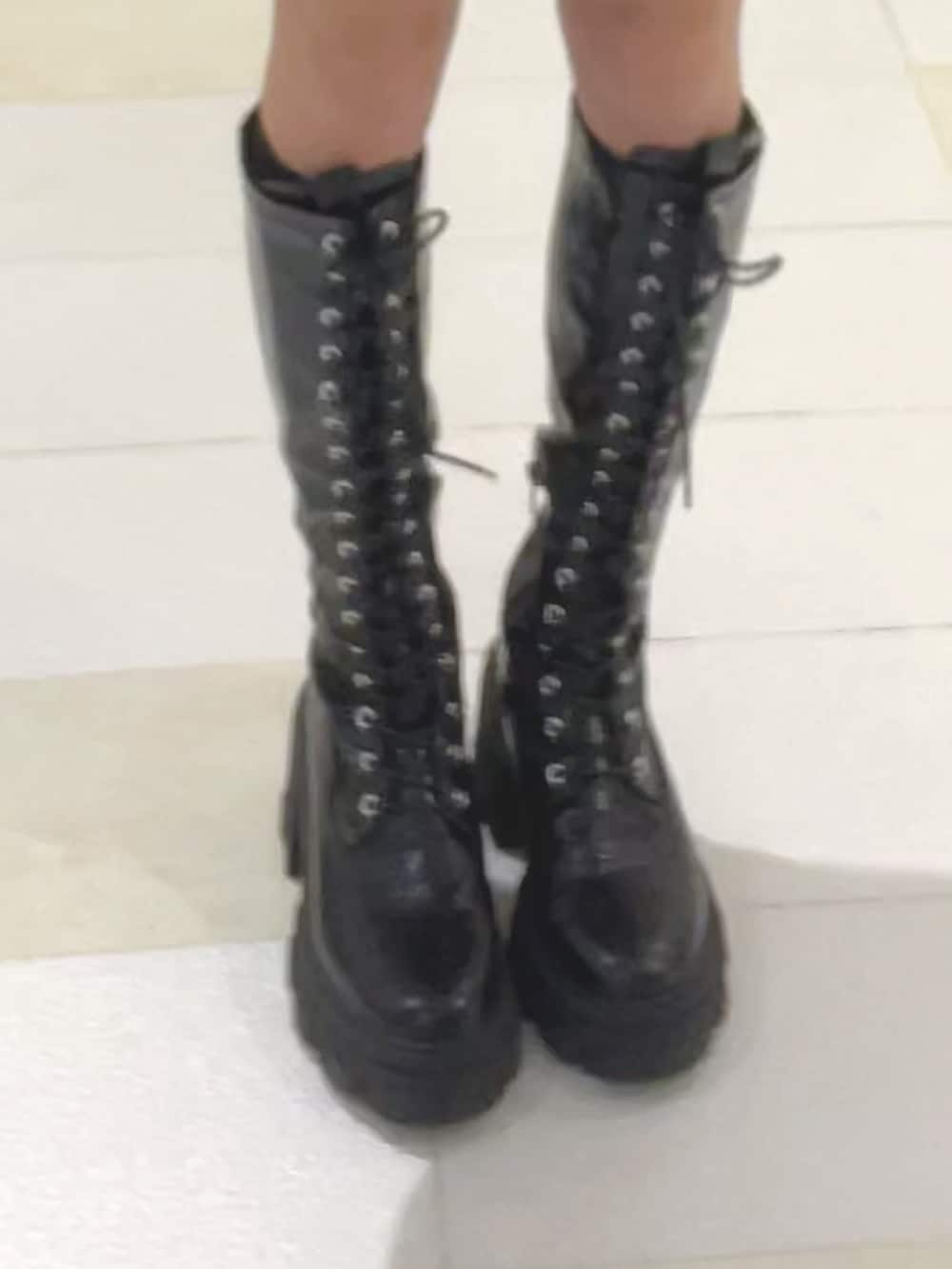 ブラック系のニット/セーター、ブルー系のスカート、ブラック系のブーツを着用したレディースの秋コーディネートの7枚目の写真