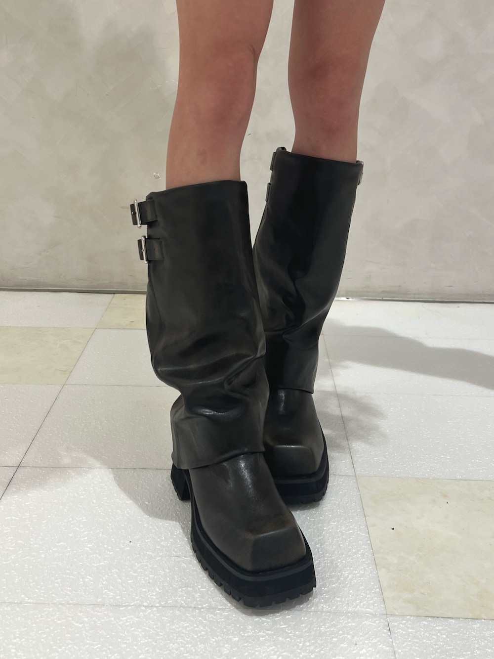 ブルー系のパーカー、ホワイト系のスカート、ブラック系のブーツを着用したレディースの秋コーディネートの7枚目の写真